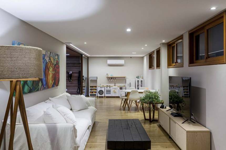 Brinquedoteca com sofá, TV, mesa das crianças e cozinha de brincar