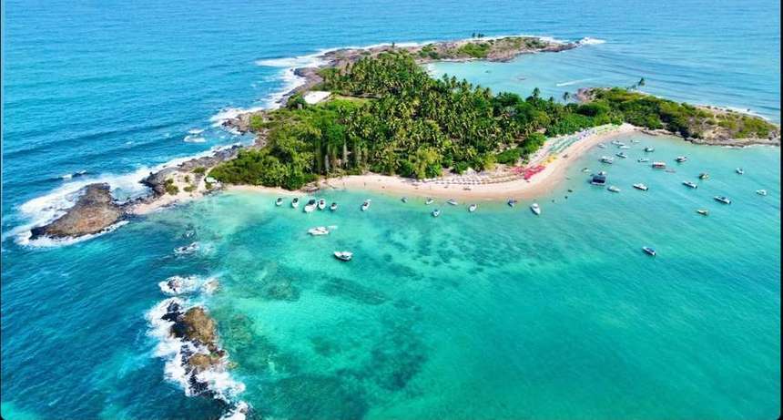 Vista aérea da Ilha de Santo Aleixo, com praia, coqueiral e lanchas fundeadas